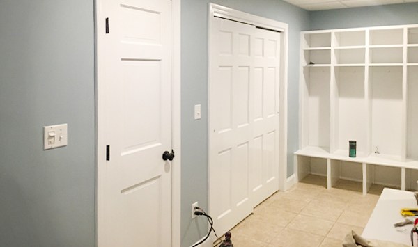 A freshly painted mudroom with white built-in storage