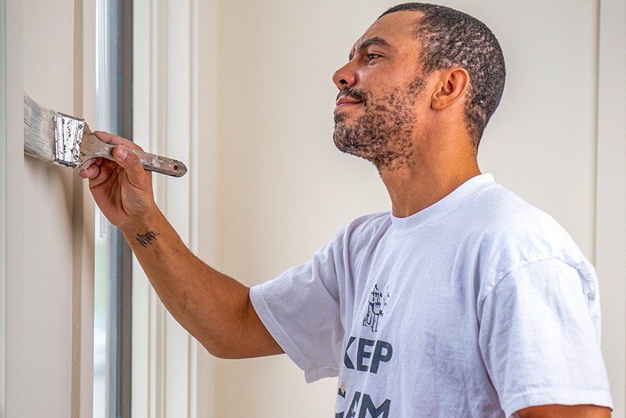 A Castle Complements painter cutting in interior trim by hand